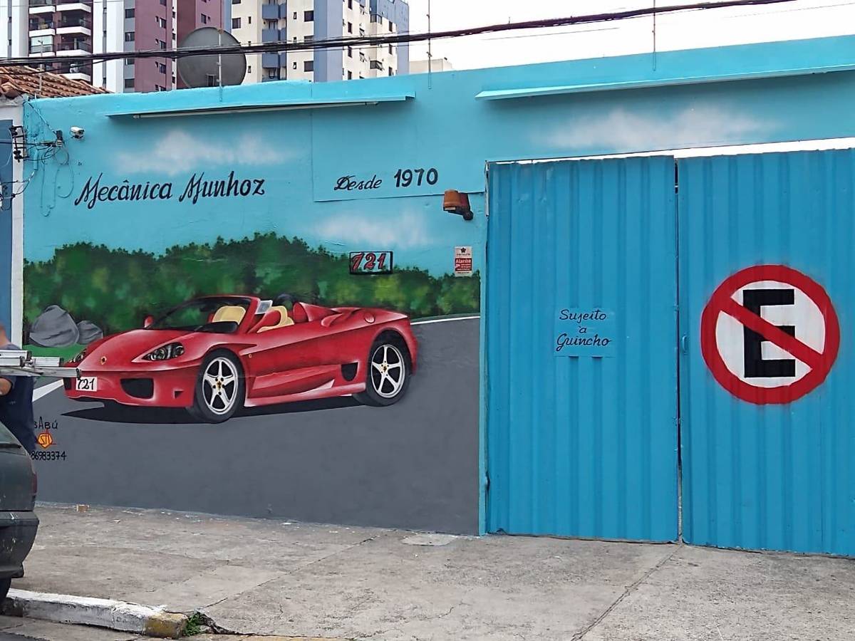 Fachada azul-turquesa da Mecânica Munhoz, pintada à mão, com o letreiro Desde 1970