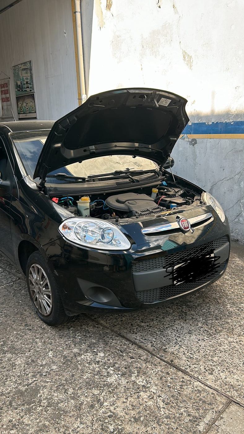 Carro com o capô aberto dentro da oficina, pronto para o diagnóstico